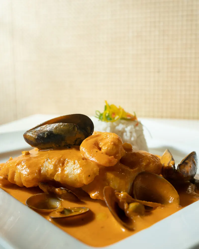 Plato de mariscos en salsa cremosa con mejillones y arroz, en Ají.