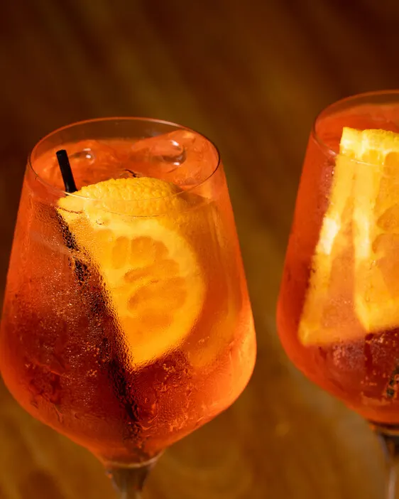 Dos copas de aperitivo naranja con rodaja de naranja, de la sesión de Encalichados.