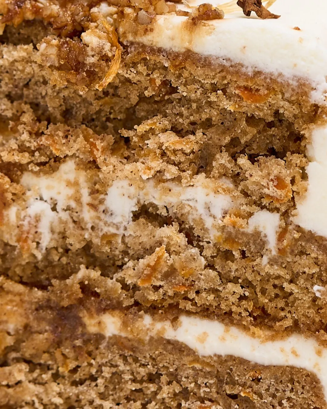 Primer plano de las capas de un pastel de zanahoria con crema.