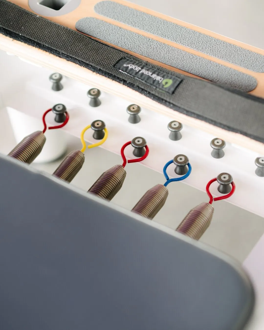 Detalle de los resortes de colores de un reformer de pilates.