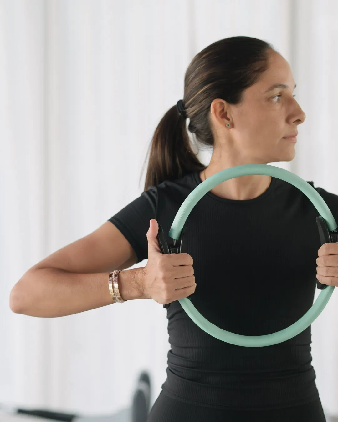 Mujer haciendo un ejercicio con un aro de pilates.